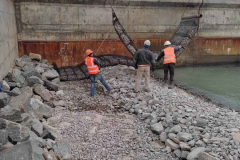 Laying gabion mattresses of the Triton system and tetrapods.